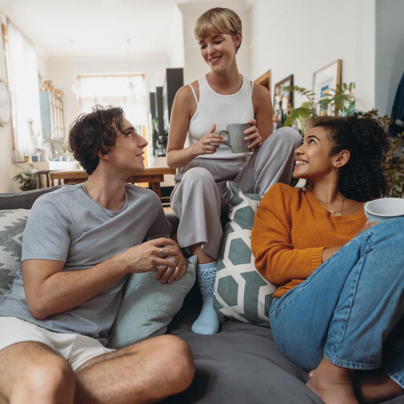 Three friends are sitting on a couch.