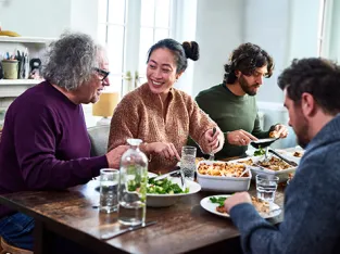 Group of mixed aged relatives sitting at dining table